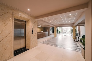A hotel lobby with a reception desk, a patterned rug, and an elevator. - Park Haven Hotel (Ha Noi)