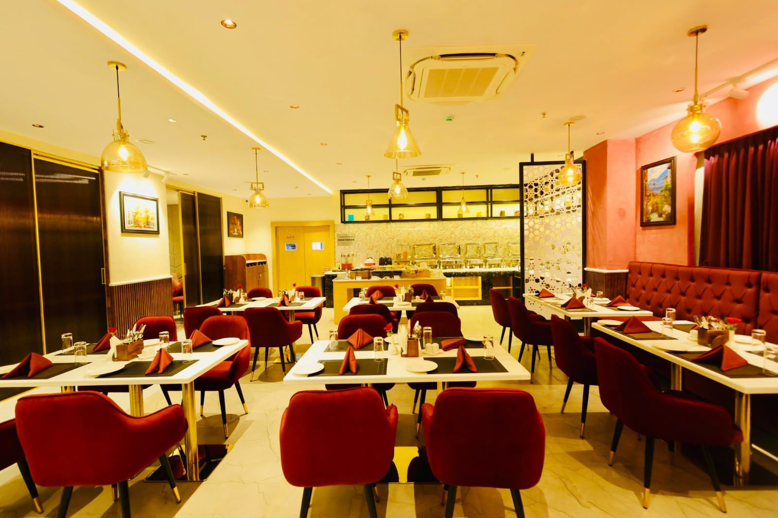 A restaurant with multiple tables and chairs, a bar area, and a seating section with cushioned booths.