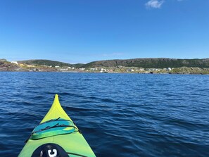 A kayak on a body of water with a coastal village in the background. - Cozy artist's retreat with an incredible view (Keels)