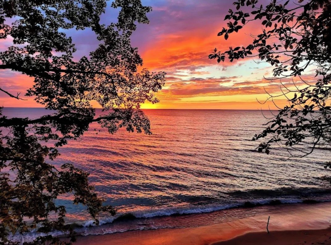 En strand med bølger og en solnedgang.
