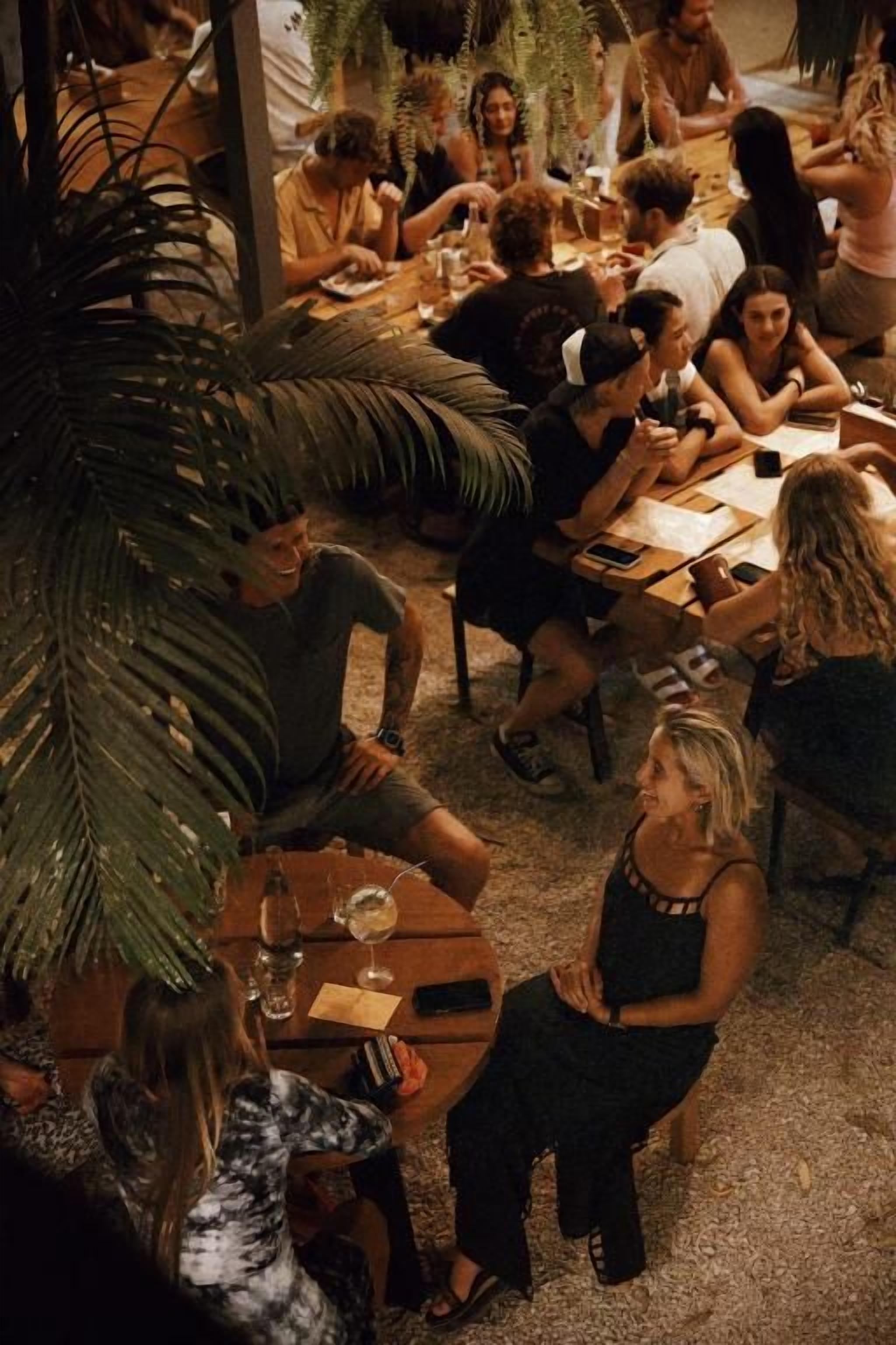 A group of people seated around a round table in a room with a visible ceiling and walls.