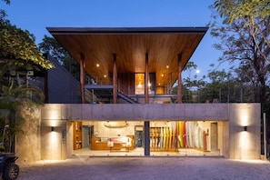 A modern building with a wooden overhang, a reception area, and a display of kayaks. - House of Somos, Santa Teresa (Santa Teresa)