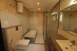 Une salle de bain moderne avec une douche à parois de verre, une baignoire, des toilettes et un lavabo.