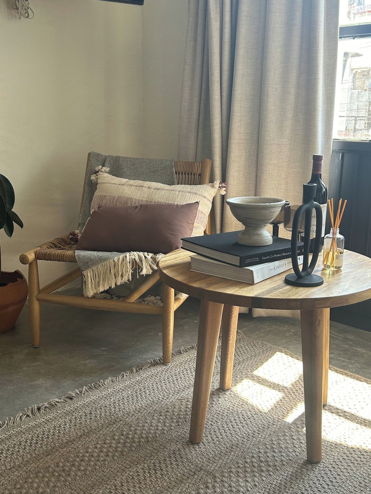 A cozy room with a wooden chair, a round wooden table, and a bookshelf.
