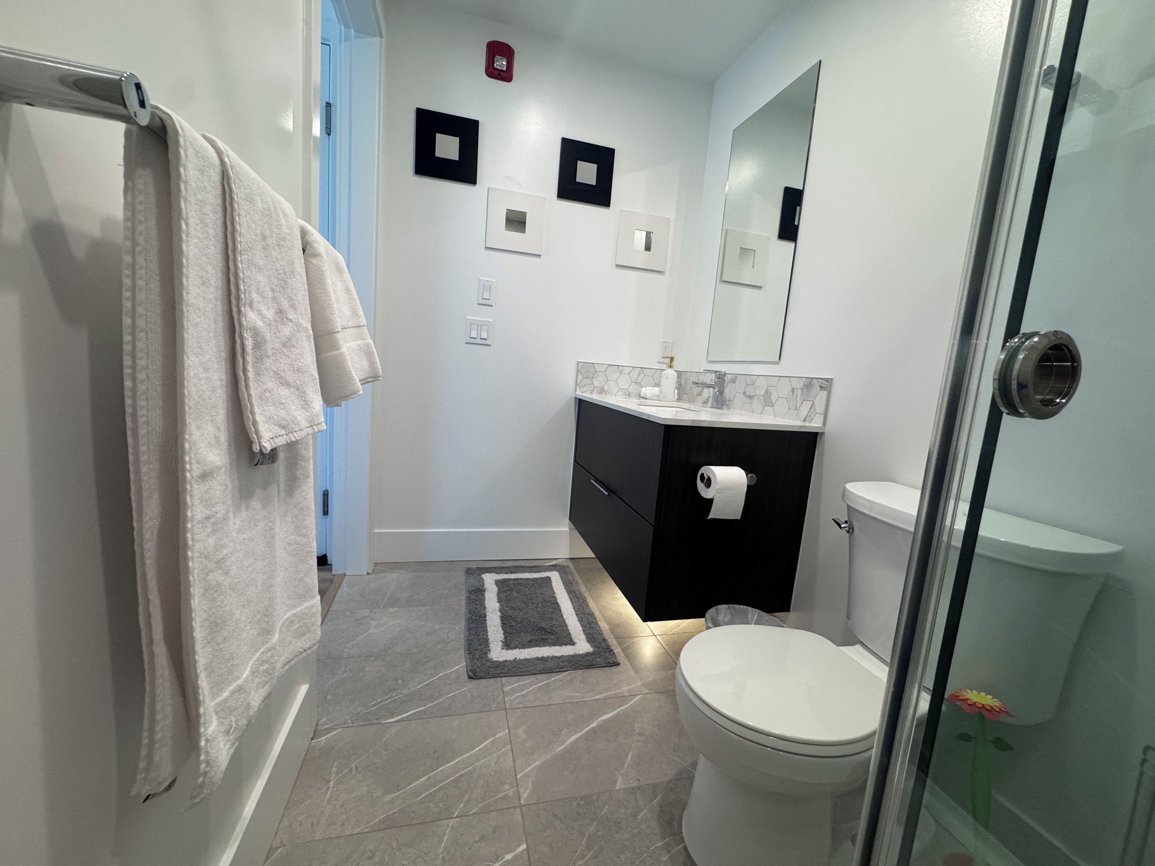 A bathroom with a toilet, sink, and shower area.