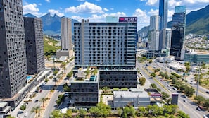 Un paisaje urbano con edificios modernos, incluyendo un hotel destacado con el letrero 'VITANT by Be Grand'.