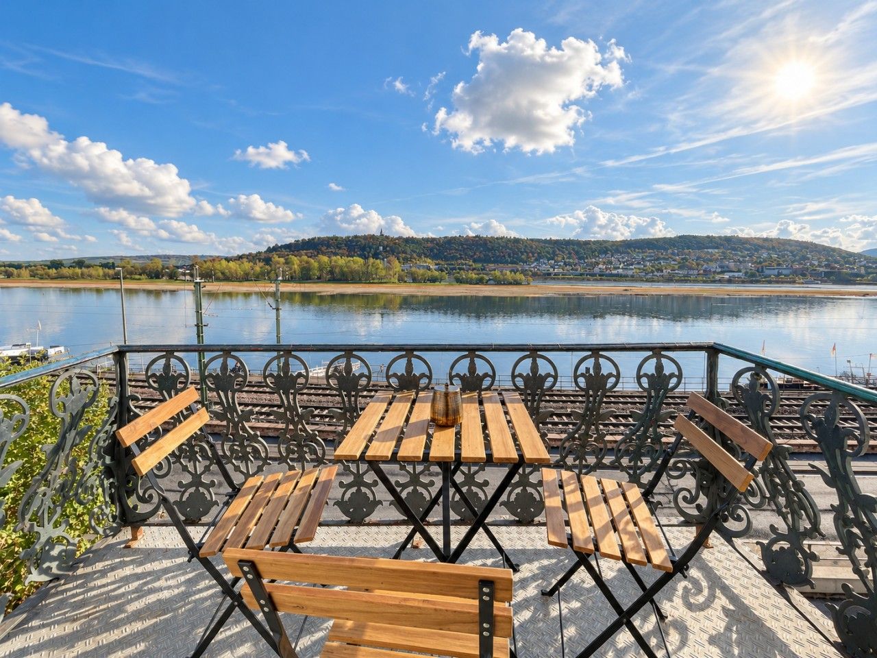 Un espace extérieur aménagé avec une table et des bancs, offrant une vue sur un plan d’eau.