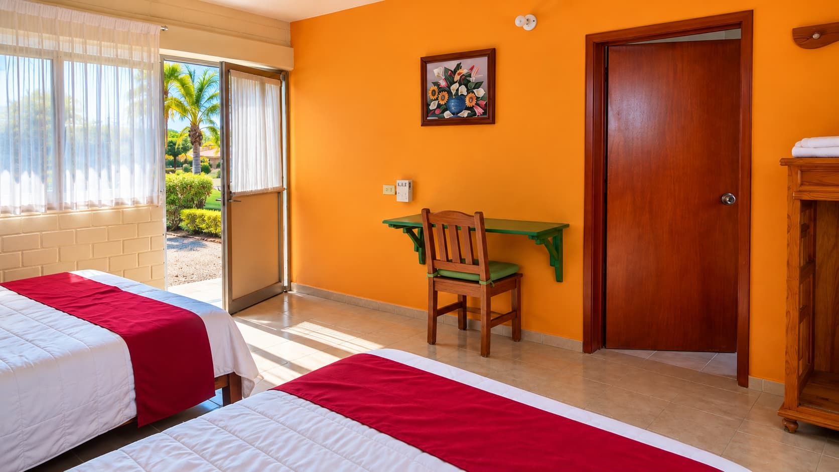 Une chambre d’hôtel avec deux lits, un bureau, une chaise et une porte.