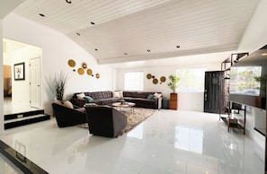 A spacious living area with a sectional sofa, a coffee table, and decorative wall art. - Resort Style Compound with detached Casita & Pool (Los Angeles)