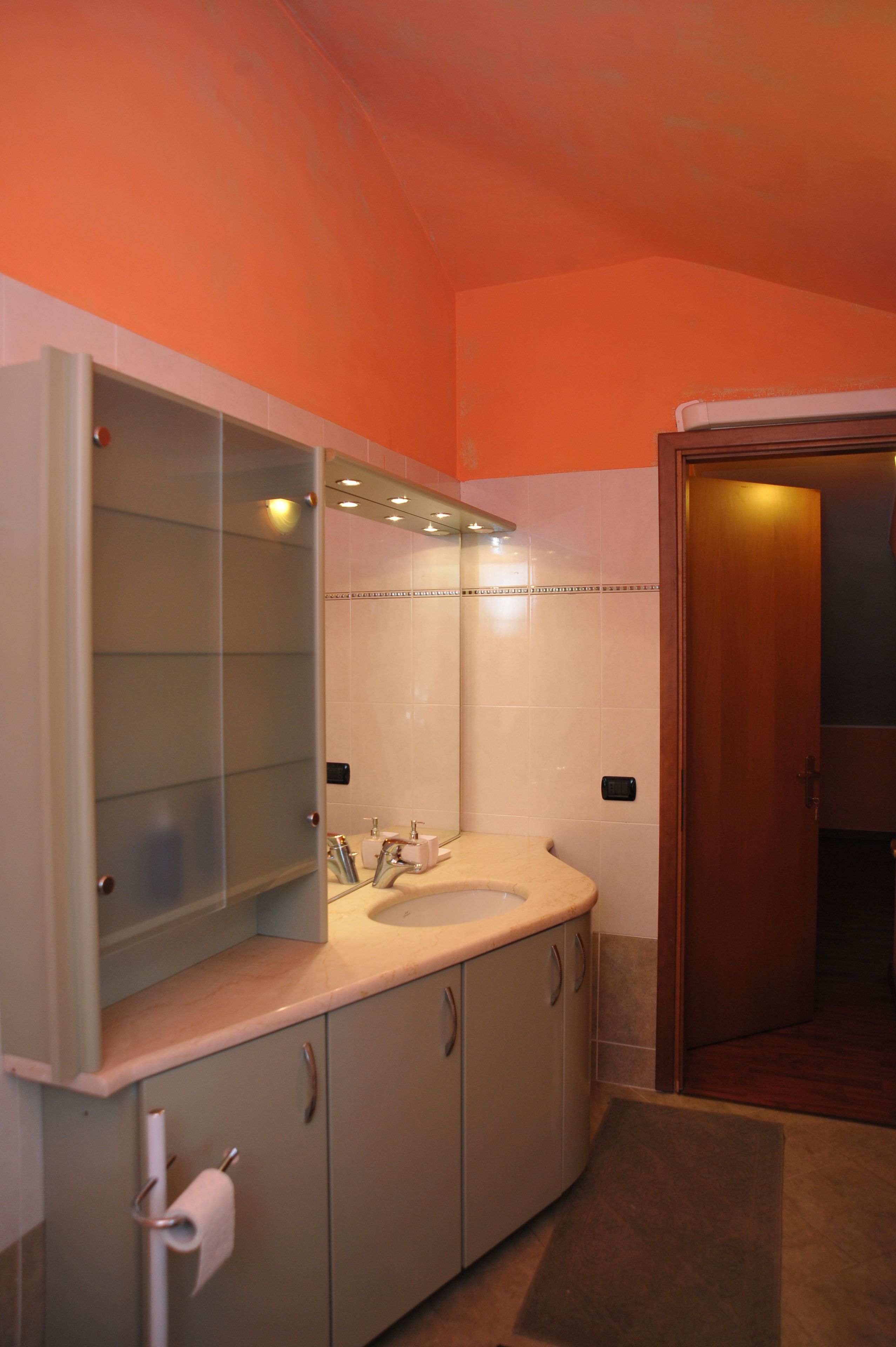 Un bagno con lavandino, specchio e mobili.