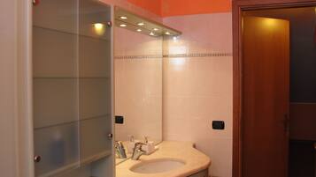 Un bagno con lavandino, specchio e mobili.