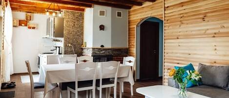 A wooden interior with a dining area, a sofa, and a kitchen.