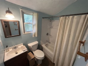 A bathroom with a toilet, sink, and bathtub.