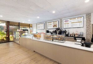 A bakery counter with a menu, coffee machines, and a display case with pastries. - Two Bedroom Deluxe Condo at Westgate Resorts in Kissimmee - Right near Disney! (Kissimmee)