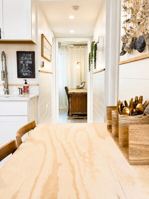 A kitchen with a marble countertop, wooden chairs, and a dining area with a table and chairs.