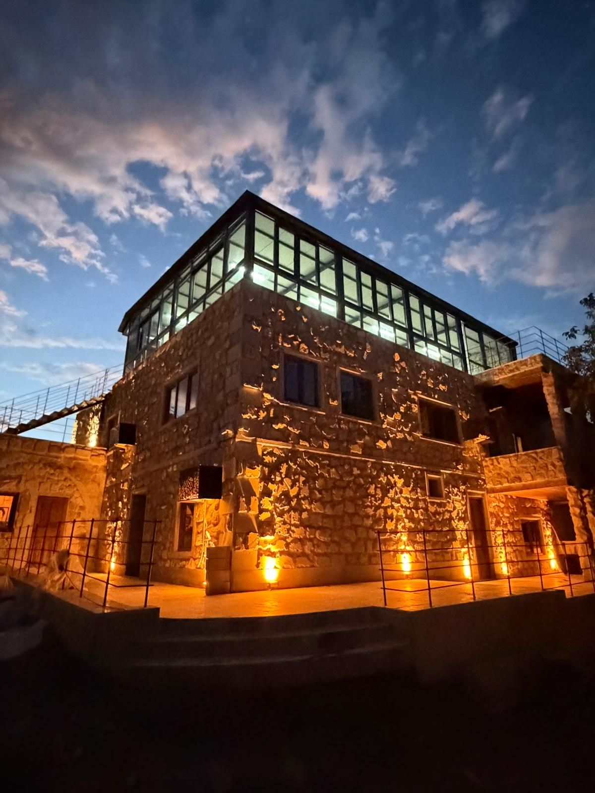 Un edificio con fachada de piedra y ventanas grandes, en construcción o renovación.