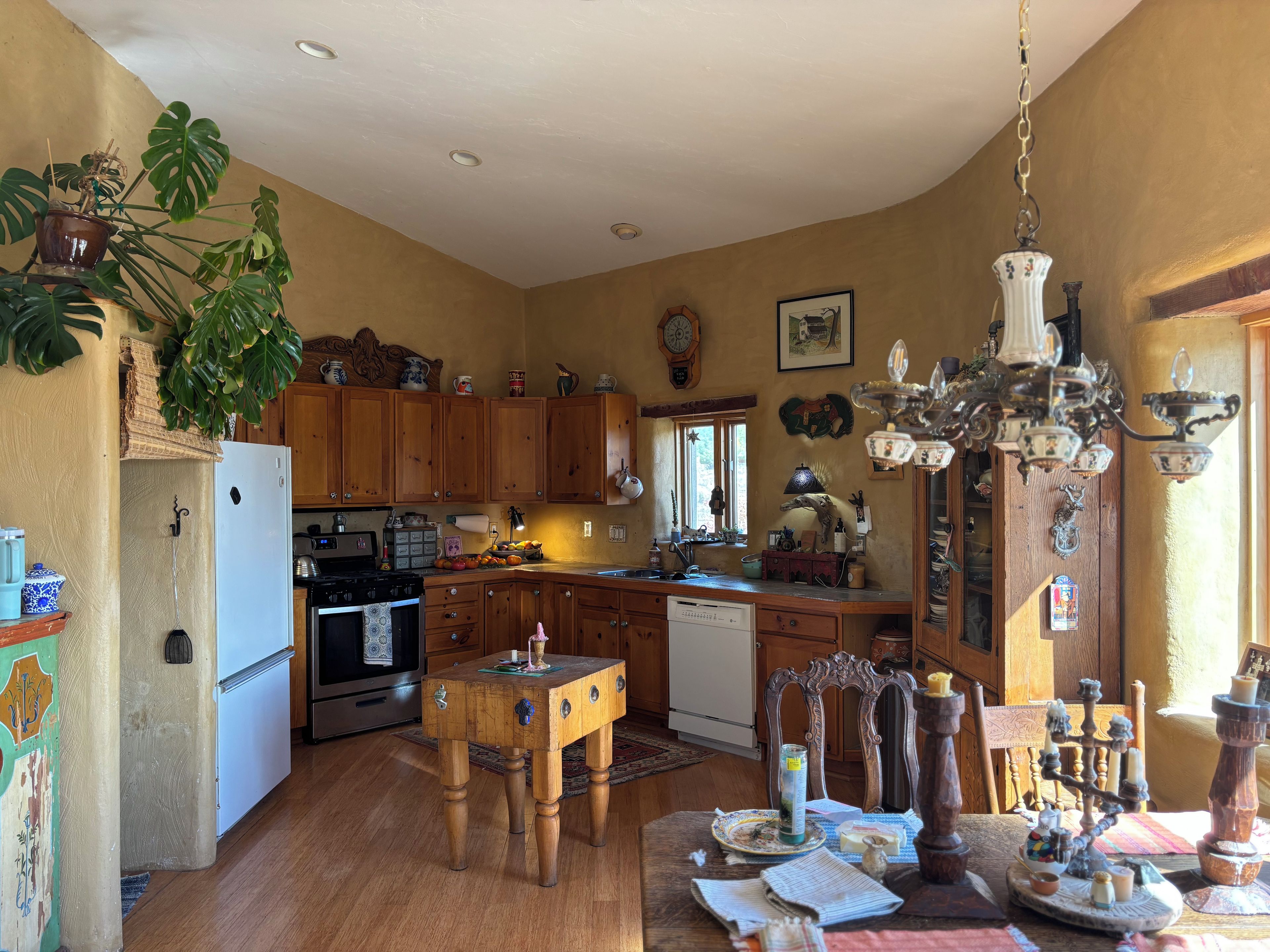 A kitchen with wooden cabinets, a dining table, and a chandelier.