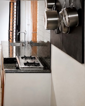 A kitchen with a gas stove, stainless steel pots, and a modern design. - Block 23 Dogwood offers cleanliness, comfort, space and reliable security. (Bacolod City)