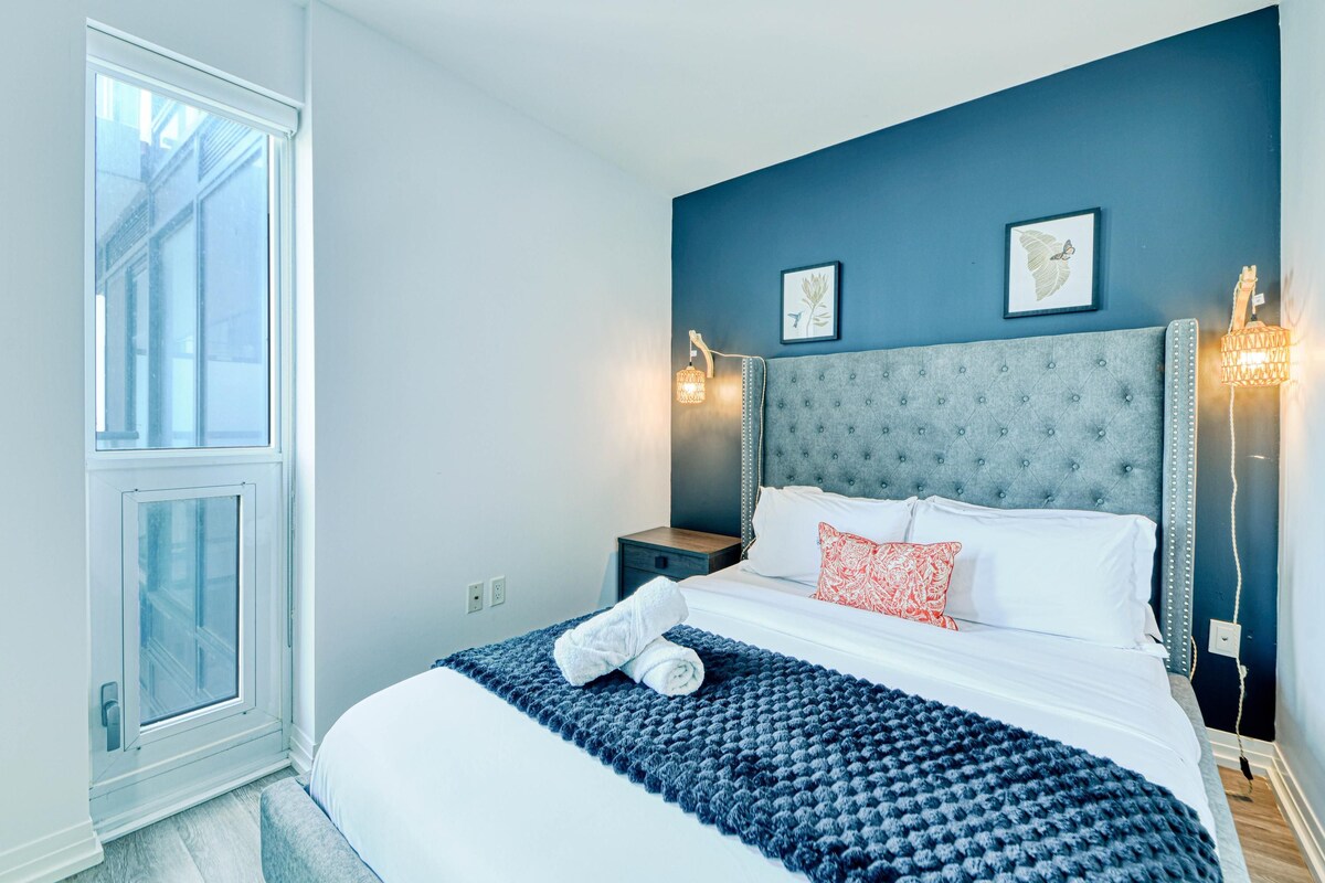 Een slaapkamer met een groot bed, een raam en twee wandlampen.