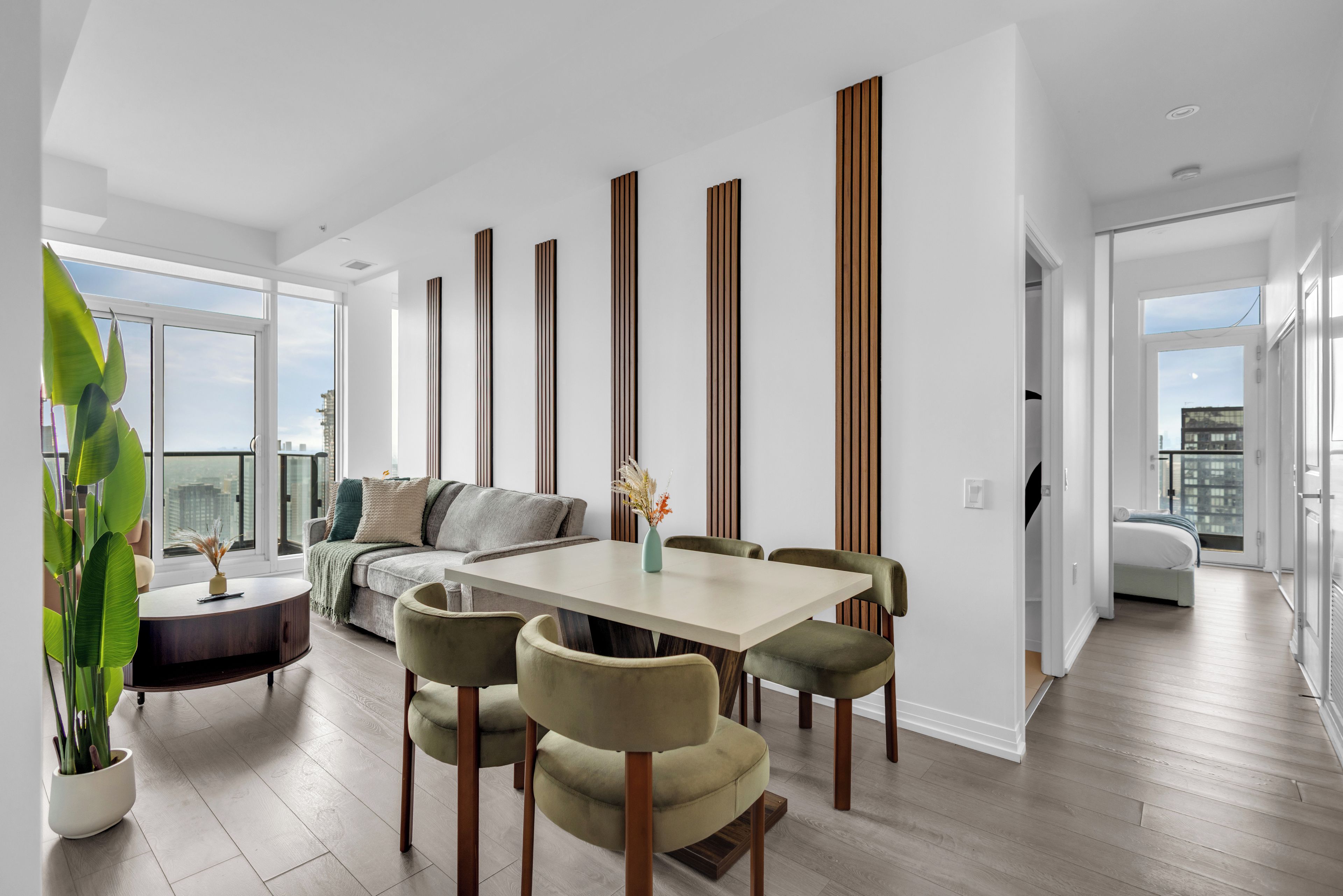 Una sala moderna con comedor, ventanas amplias y vistas a la ciudad.