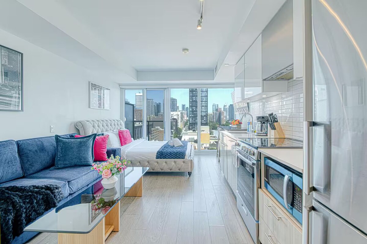 Een modern appartement met een woonehoek, een slaapkamer en een keuken.