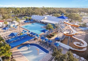 Área de piscina com toboágua e espreguiçadeiras.