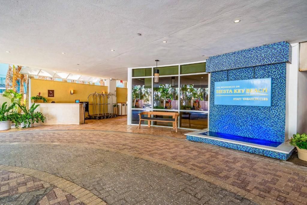 Un hall d’hôtel comprenant un comptoir d’accueil, un espace salon et un mur décoratif.