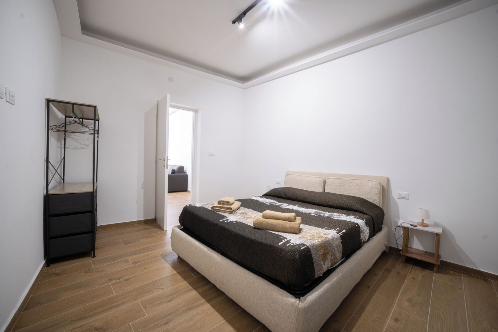 Une chambre à coucher avec un lit, une armoire et une table de chevet.