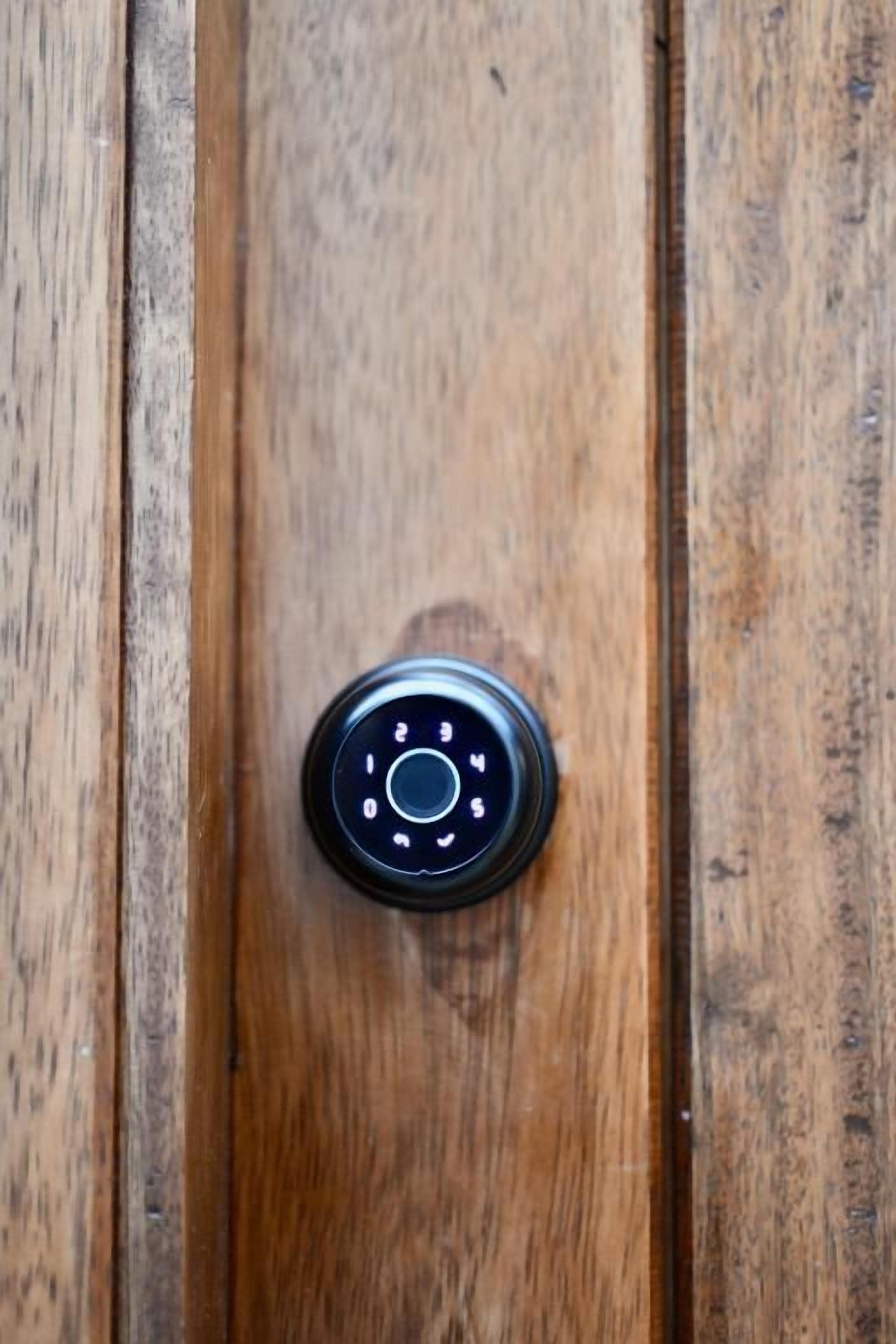 Une porte en bois dotée d’un clavier numérique noir et rond pour le verrouillage.