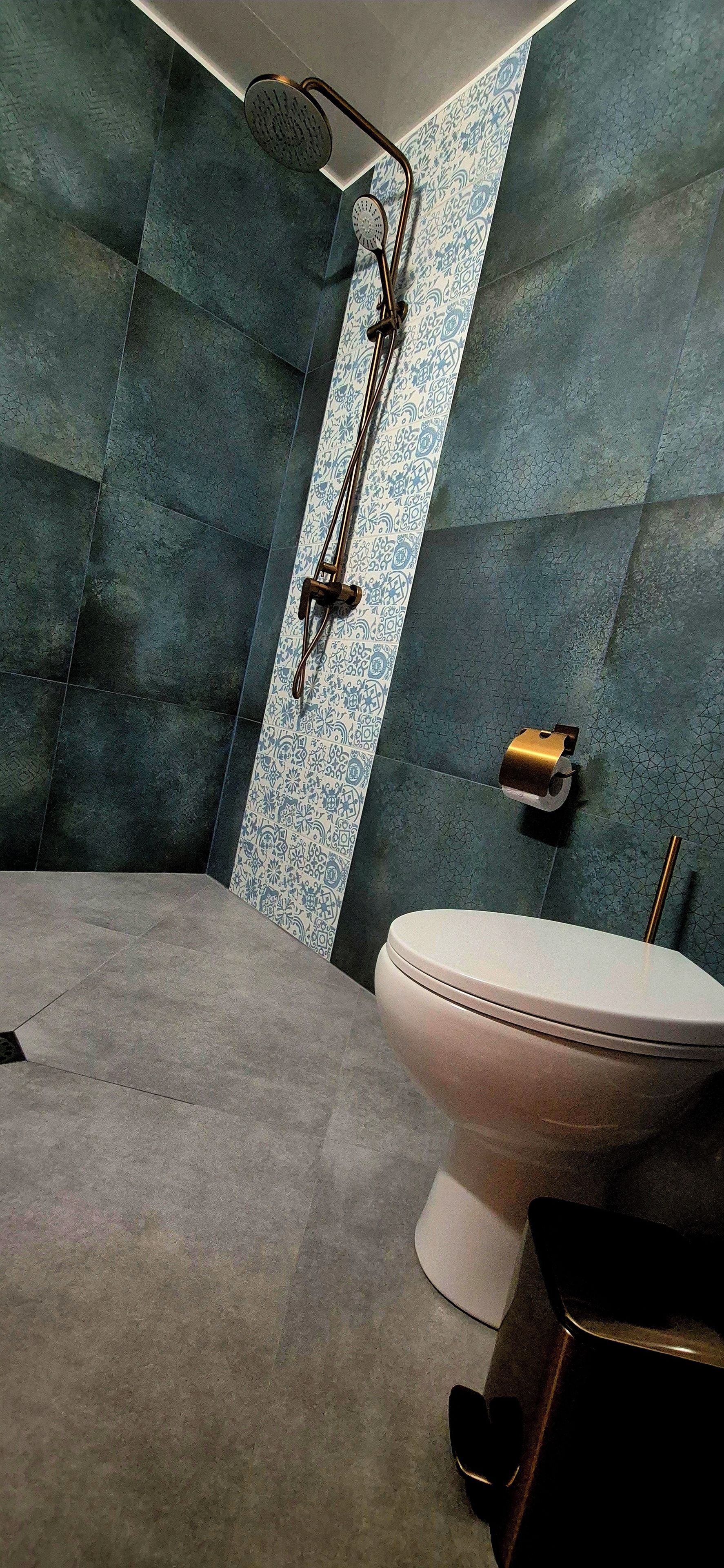 Ein Badezimmer mit Dusche, Toilette und Handtuchhalter.