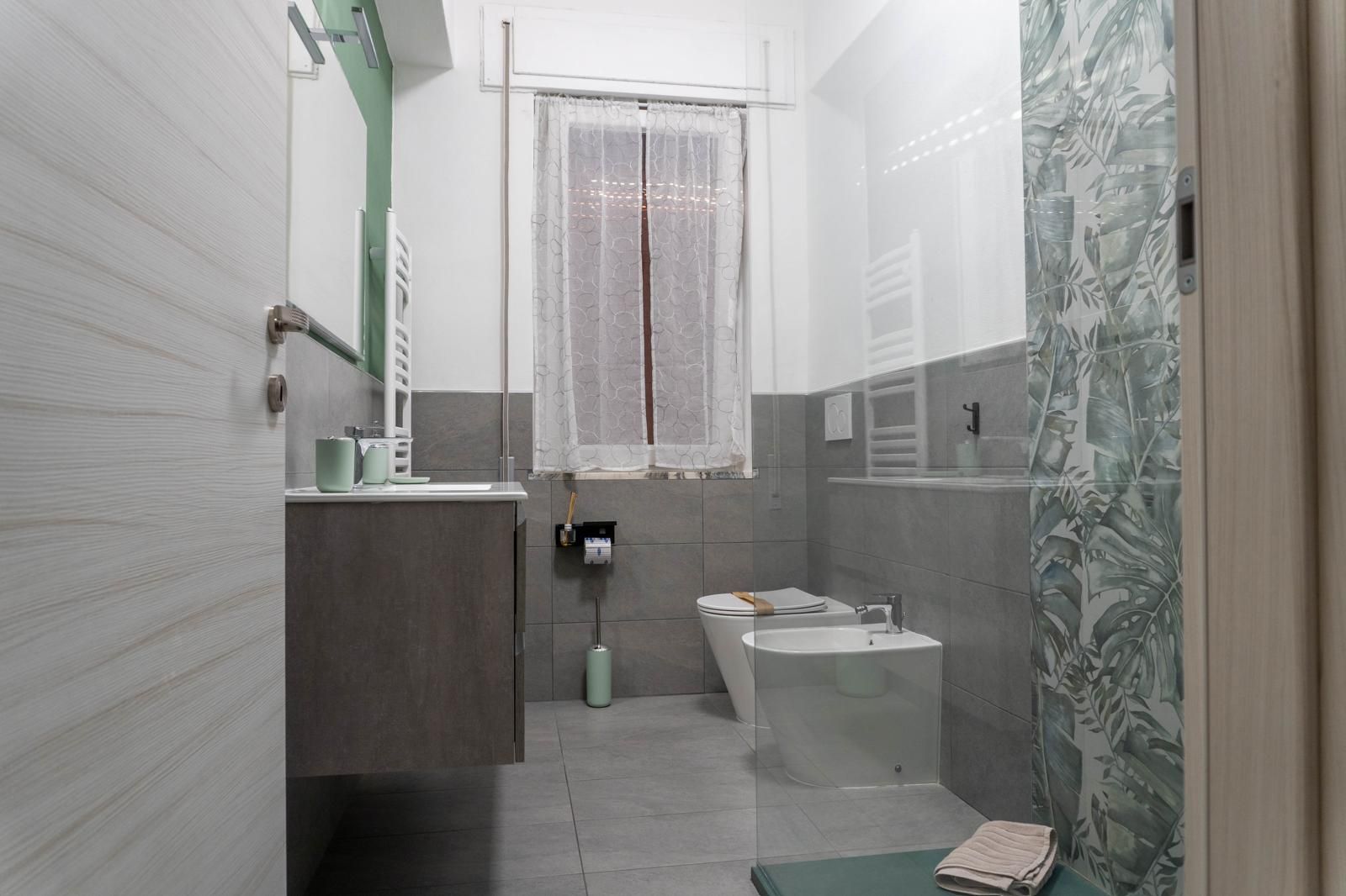 A bathroom with a toilet, sink, and shower area.