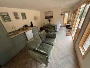 A compact living space with a kitchenette, a sofa, and a dining area.