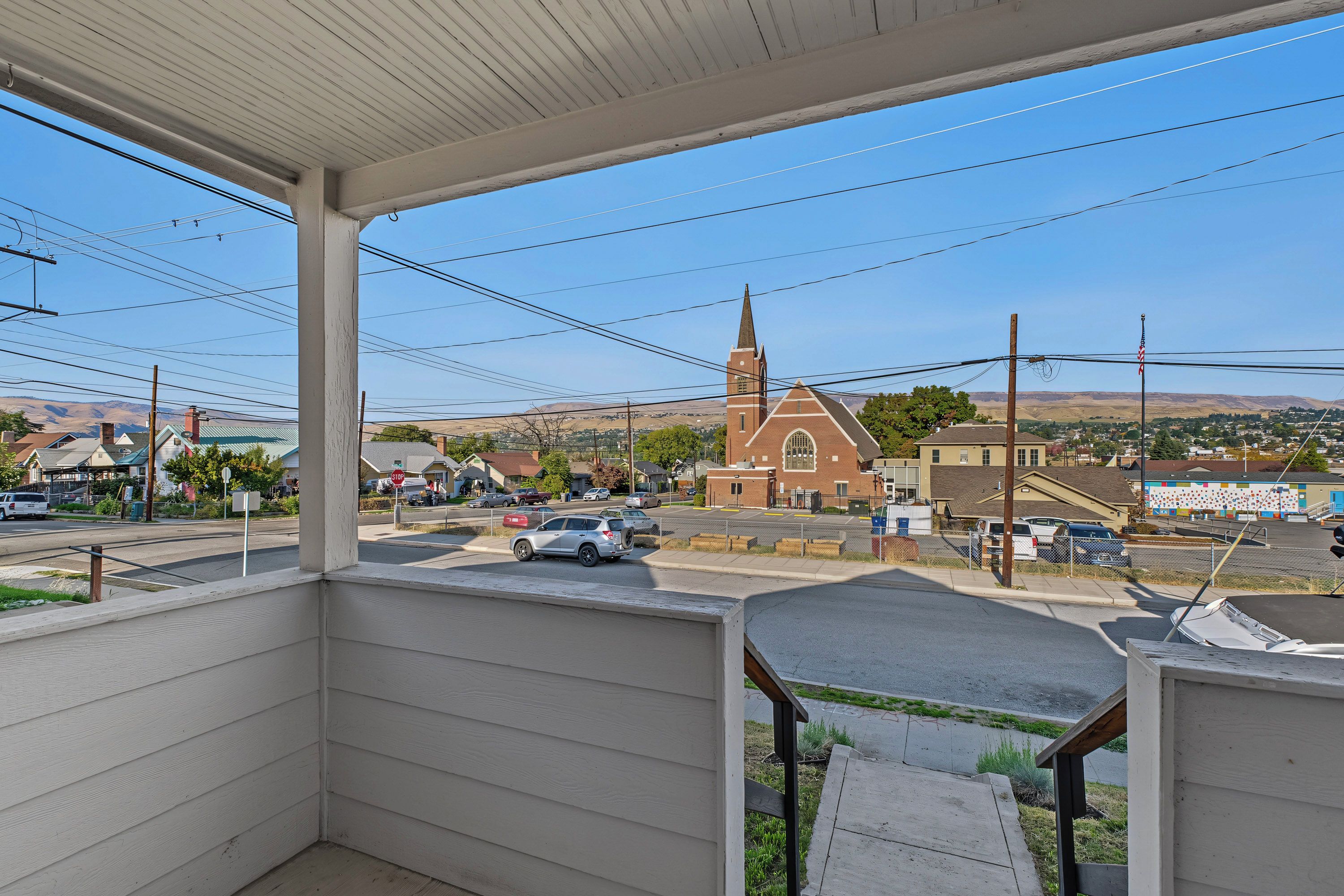 A residential area with a church, a parking lot, and a clear view of the surrounding landscape.