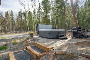 Eine mobile Outdoor-Küche mit Grill, Whirlpool und Sitzgelegenheit.
