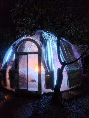 A transparent dome structure with a visible interior, a door, and a window. - Domus Olea Ecobio house (Oliveto Citra)