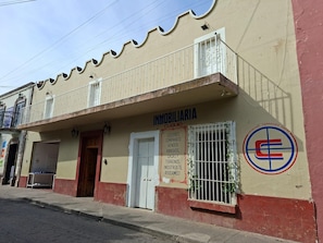 A two-story building with a sign that reads 'INMOBILIARIA' and a logo with a stylized 'E'. - casona arcana  (Cuquío)