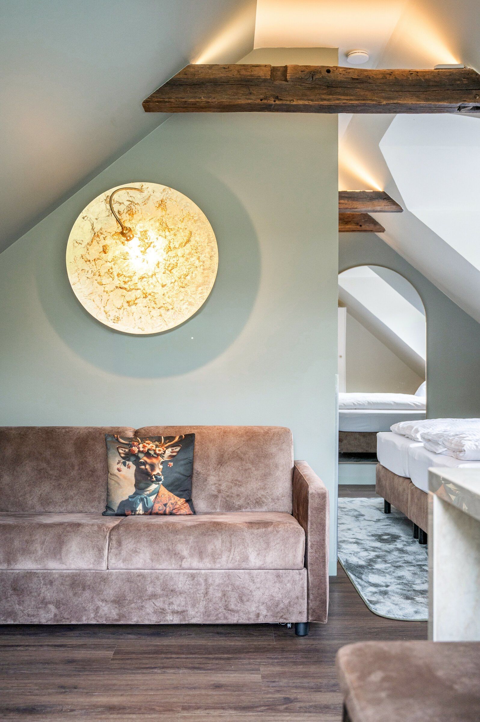 Ein modernes Interieur mit einer Couch, einem runden Wandkunstwerk und einer Treppe.