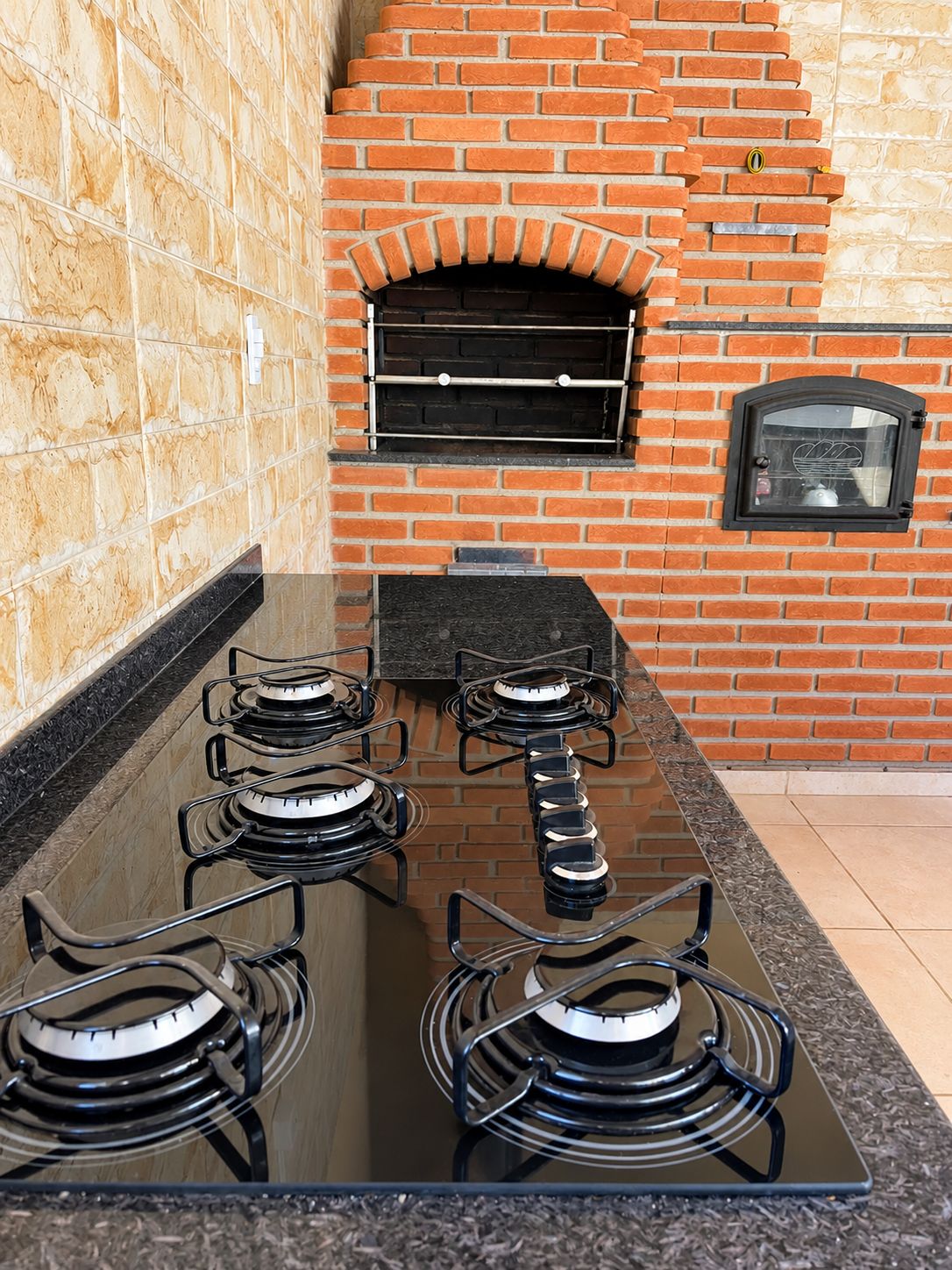 Een keuken met een bakoven, een gasfornuis en een raam.