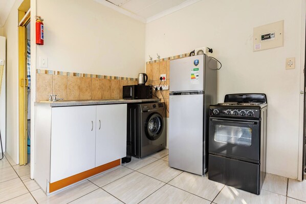 A compact kitchen with a washing machine, a refrigerator, and a stove.