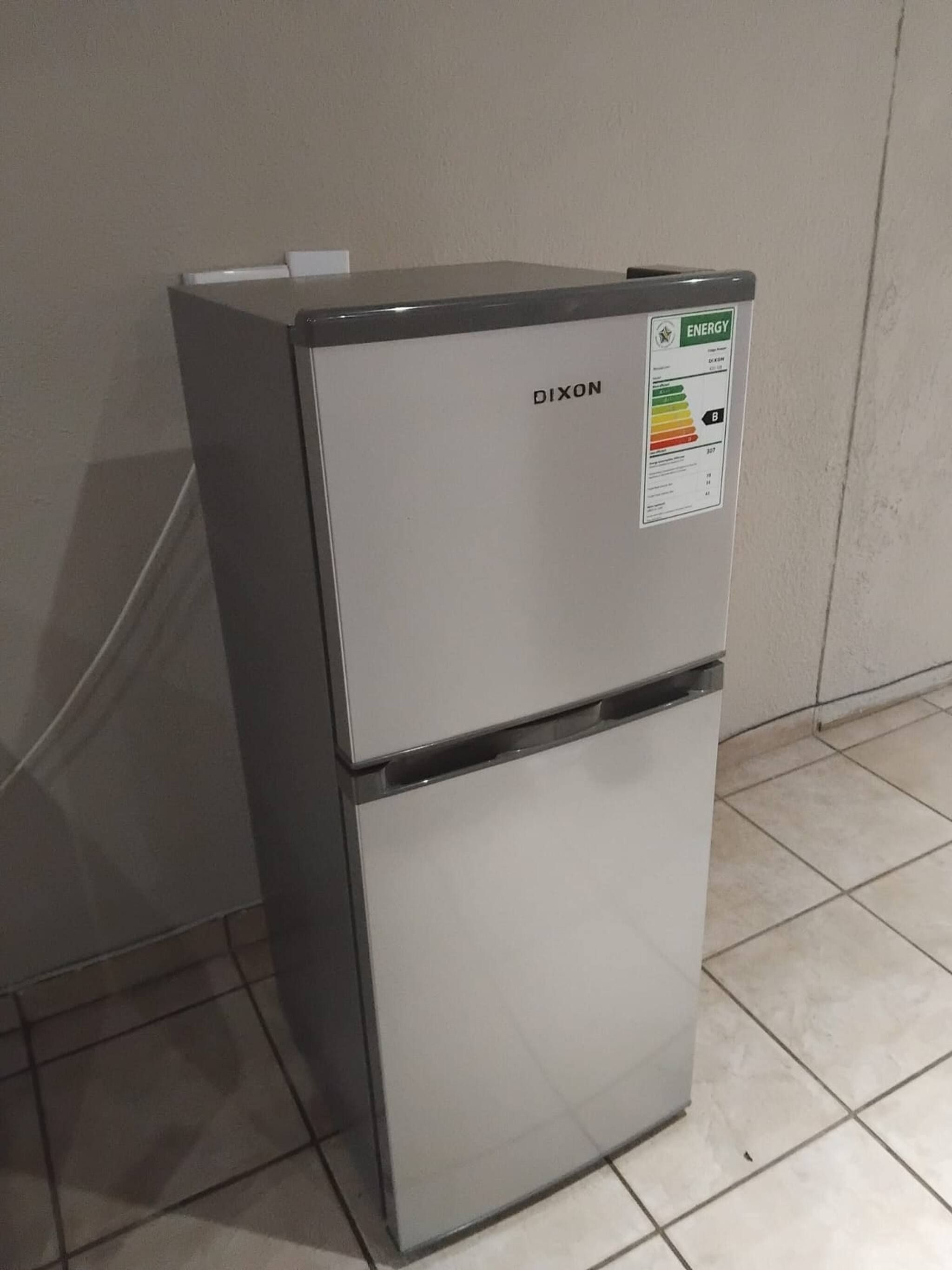 A white refrigerator with a sticker indicating energy efficiency.