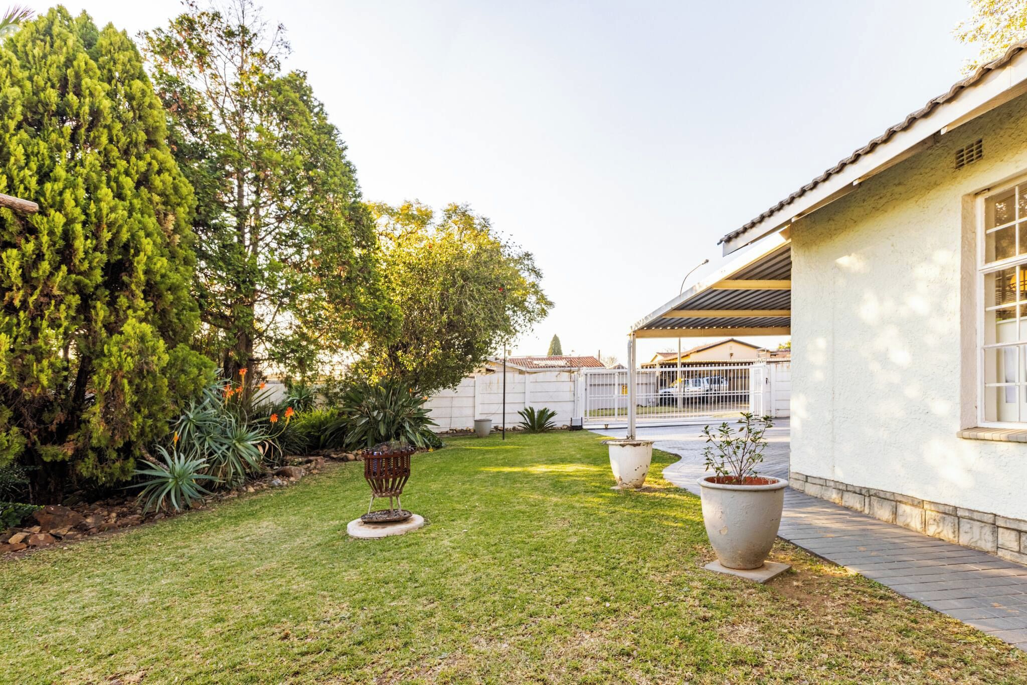 Un jardín bien cuidado con diversas plantas y una pequeña estructura decorativa.