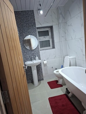 A bathroom with a white sink, a toilet, and a bathtub. - House Sleeps 5 With Wifi (Ilford)