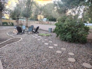 Un espace extérieur aménagé en terrasse, avec des sièges et un chemin de gravier.