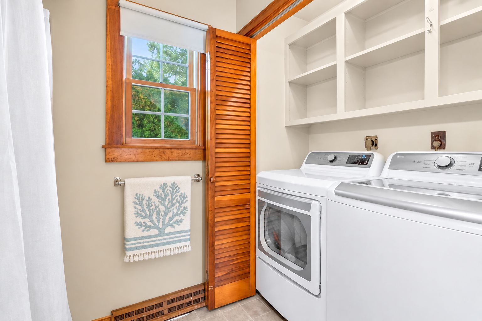 Une buanderie avec une porte en bois, une fenêtre et un lave-linge blanc.