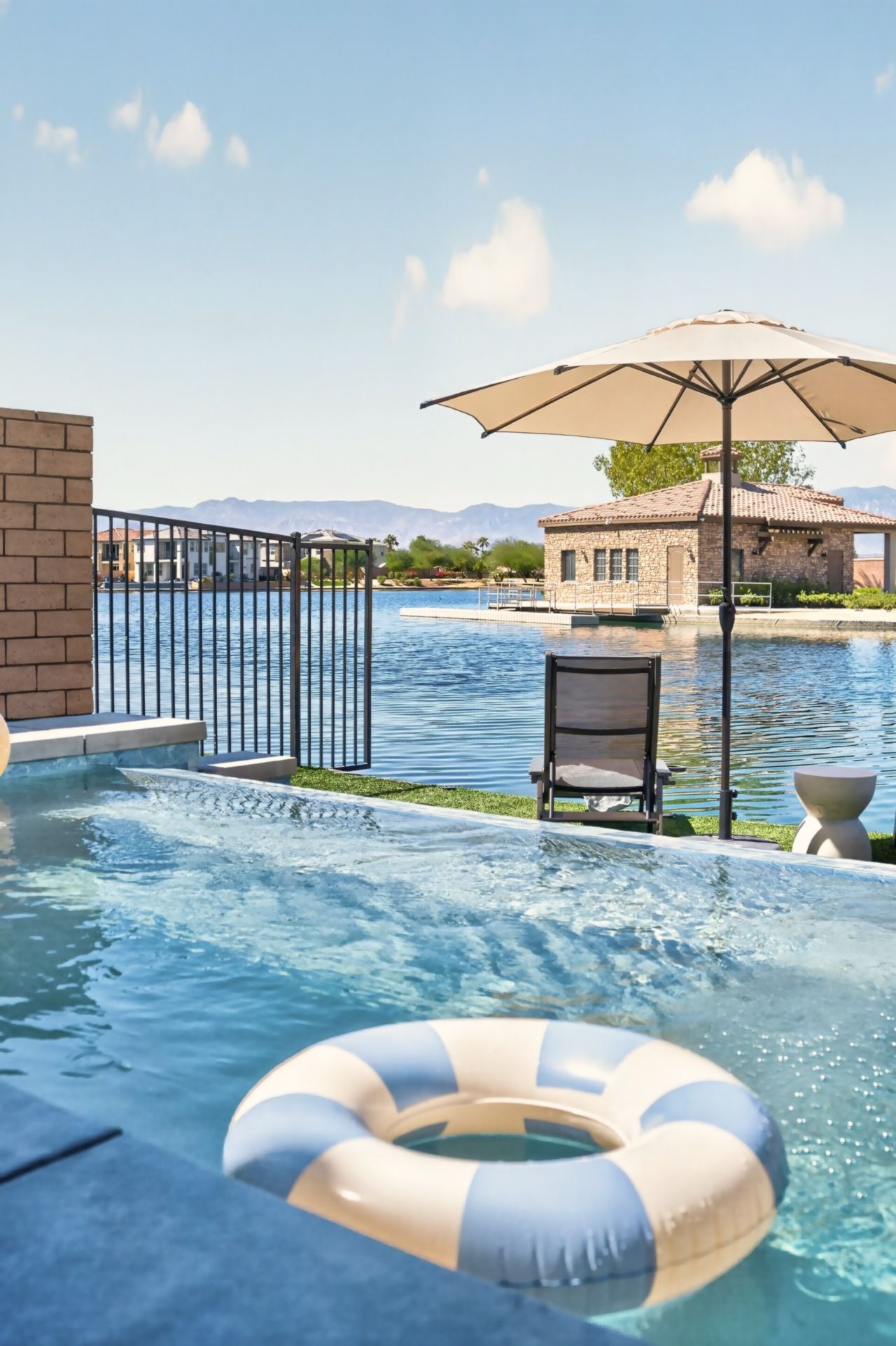 A swimming pool with a lifebuoy, a chair, and an umbrella.