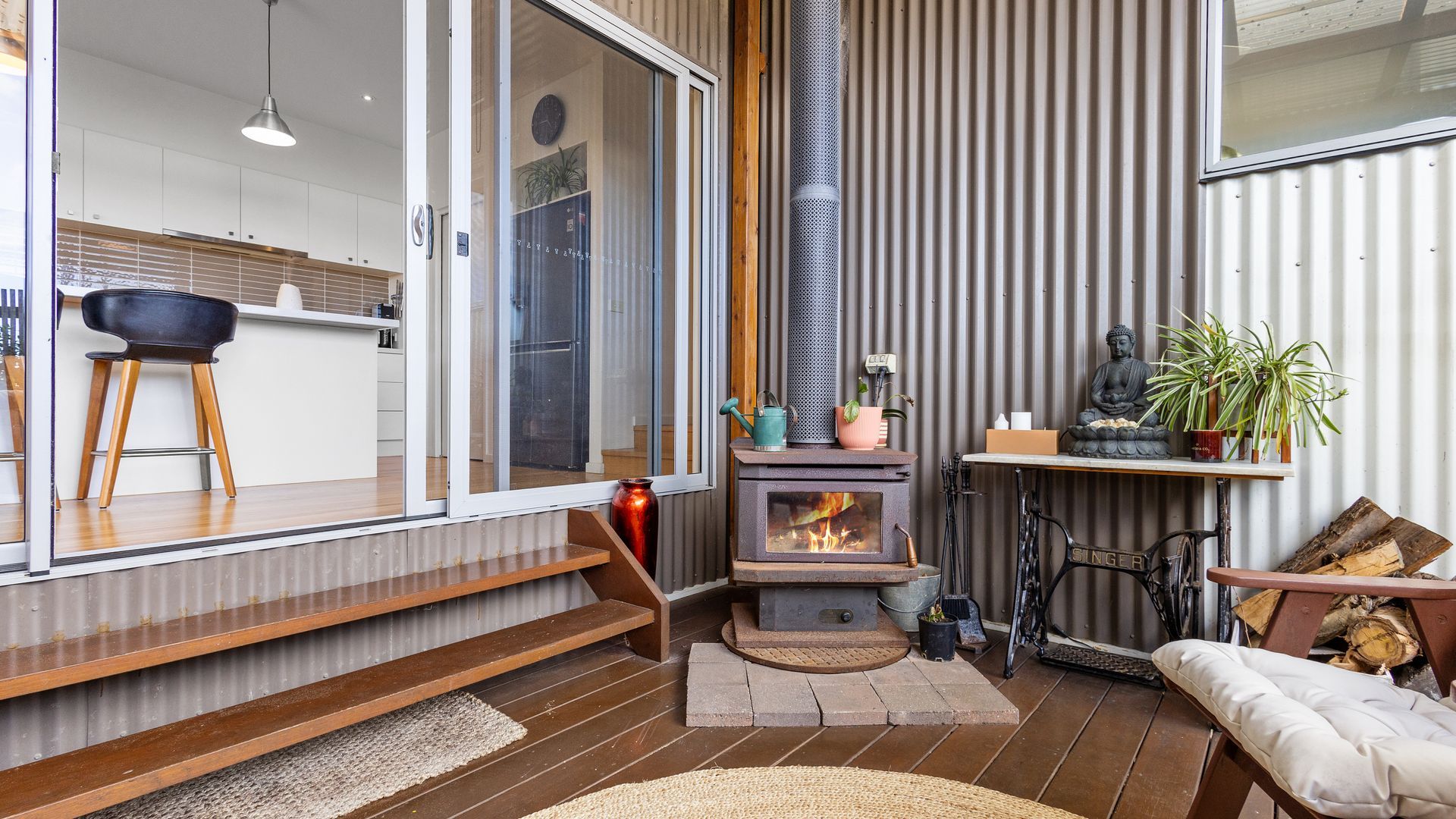 A cozy living area with a fireplace, a bench, and a small table with plants.