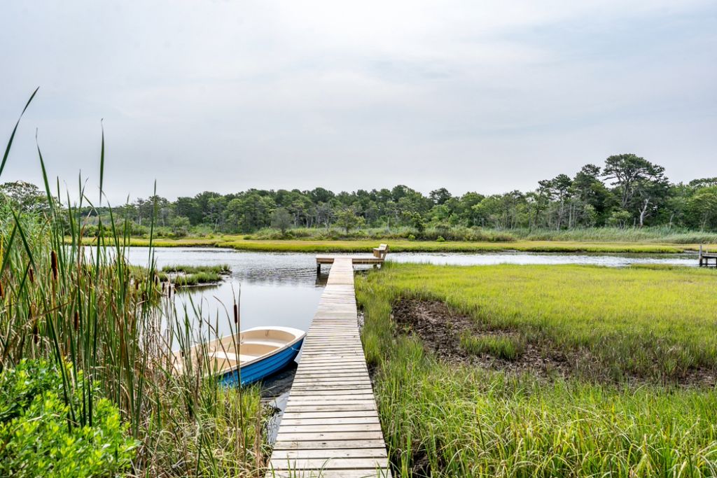 A wooden dock extending into a body of water, with a boat docked at the end.