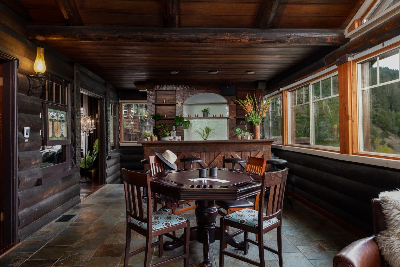 Een houten interieur met een eettafel, stoelen en een bar.