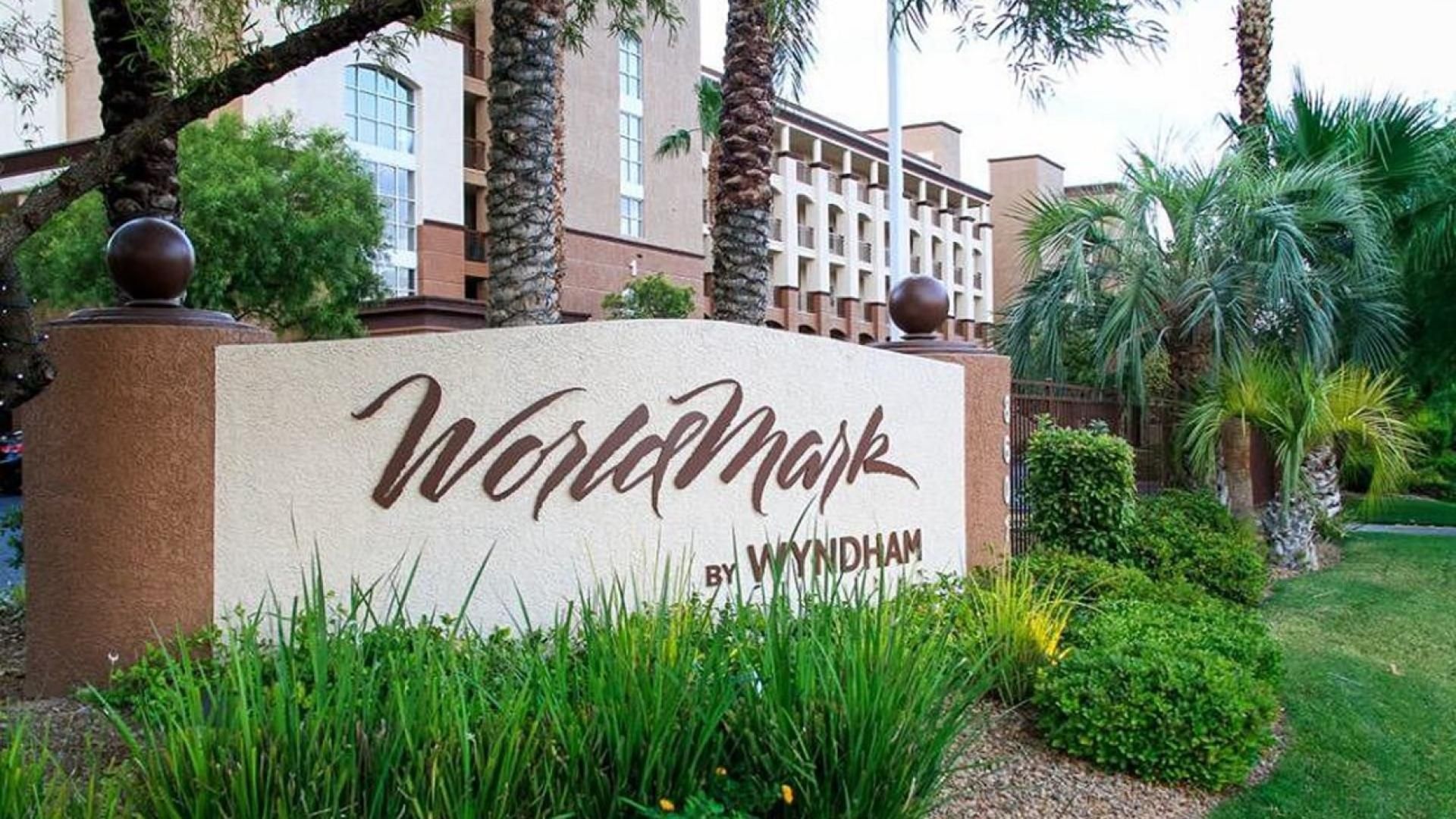 A sign with 'Worldmark by Wyndham' written on it, surrounded by greenery and palm trees.