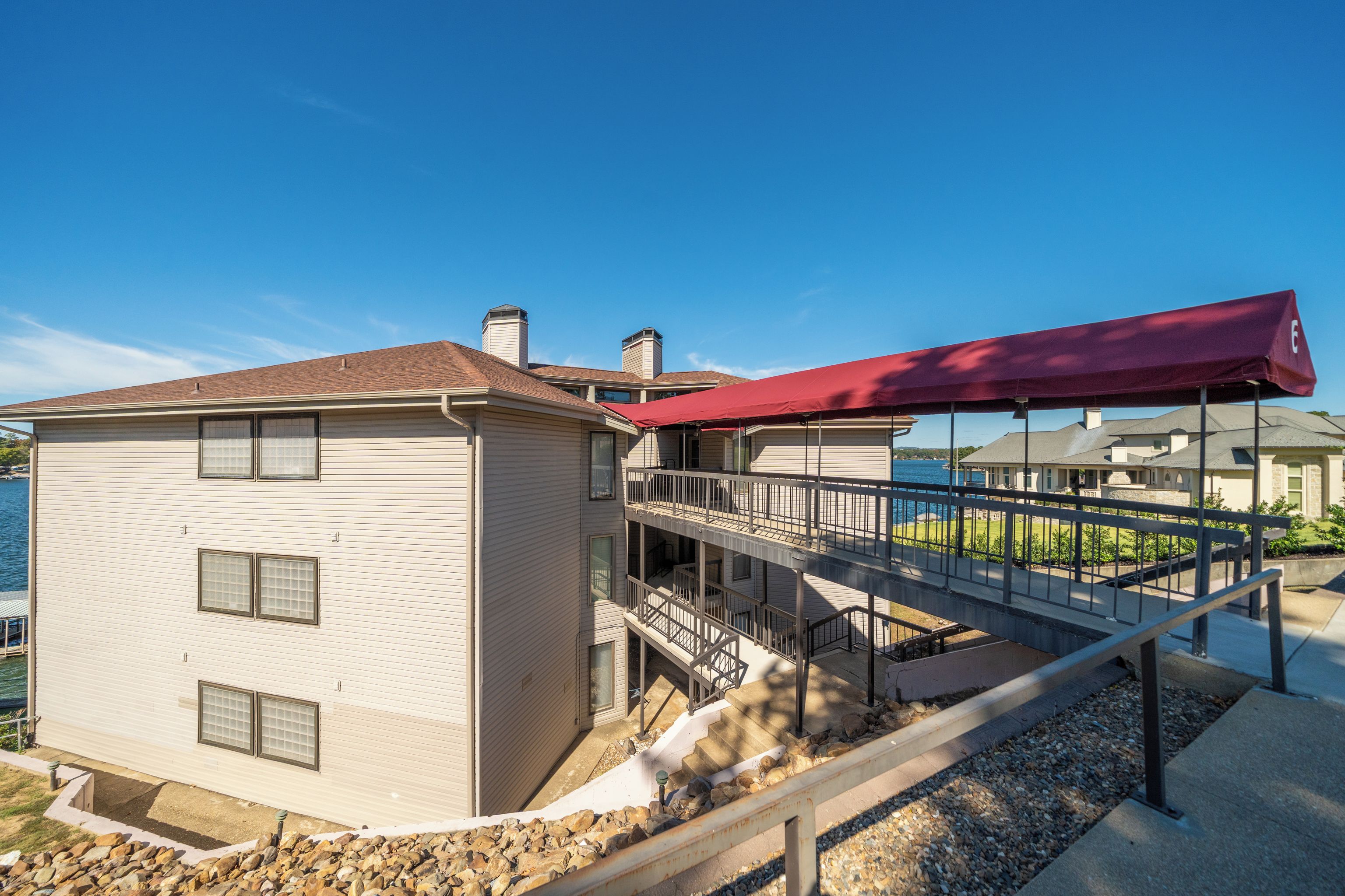 A two-story building with a balcony and a red awning.
